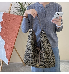 Close-up of leopard print hobo bag with bow detail and handmade metal nameplate