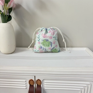Close-up of floral drawstring pouch with mint green fabric and rose patterns
