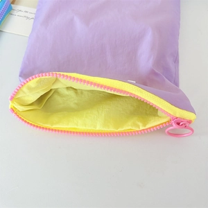 Detail of lavender makeup pouch with vibrant yellow lining and pink plastic zipper