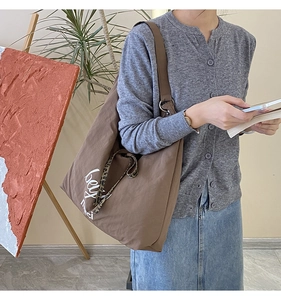 Close-up of brown canvas hobo bag with white typography and leopard print drawstring detail