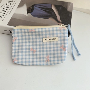 Close-up of blue plaid floral coin purse with zipper and blue woven pull cord