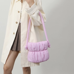 Bolso plisado lila suave combinado con un abrigo beige y una falda marrón de moda