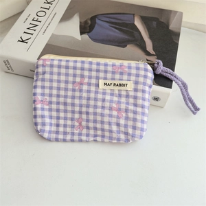 Close-up of purple checkered canvas floral coin purse with a pink bow and drawstring
