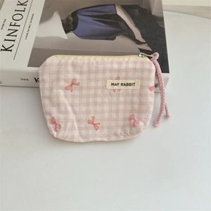 Detail of pink plaid floral makeup pouch with metal zipper and purple drawstring