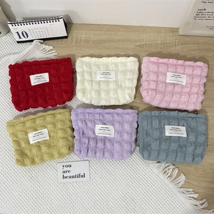 Bubble seersucker mini makeup bags in six pastel colors shown from a high-angle view