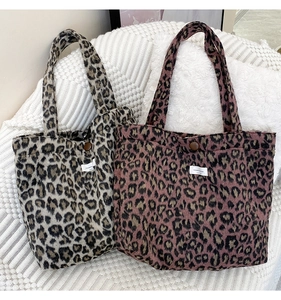 Détail d'un sac cabas en fausse fourrure léopard avec fermeture aimantée et étiquette tissée