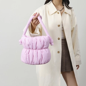 Detalle de bolso nube acolchado rosa claro con asa anudada y textura de pliegues