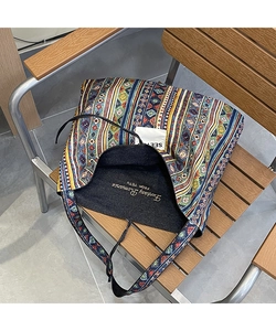 Close-up of ethnic stripe canvas tote bag with embroidered interior and boho patterns