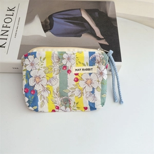 Detailed macro of floral canvas coin purse with blue cotton rope and silver zipper