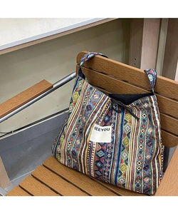 Detail of bohemian patchwork denim bag with geometric patterns and SEE YOU woven label
