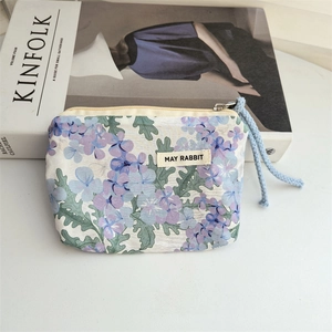 Detail of floral cotton coin purse with drawstring and MAY RABBIT label on white desk