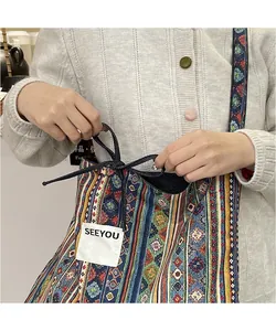 Detailed close-up of ethnic style patchwork shoulder bag with colorful geometric patterns