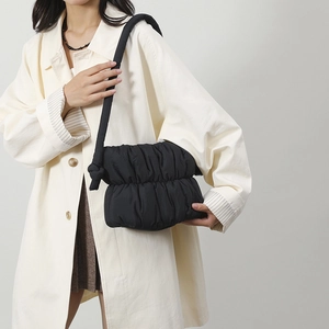 Detalle del bolso nube plisado negro en nailon suave con correa de hombro con nudo