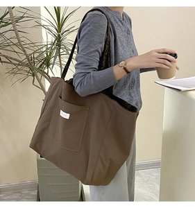 Detail of dark brown tote bag showing long shoulder strap and leopard print lining