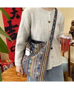 Detailed shot of ethnic patchwork canvas bag with colorful geometric patterns and SEEYO label