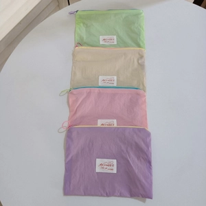 Set of four pastel macaron makeup pouches in green, beige, pink and purple with ring zippers