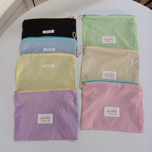 Set of seven macaron-colored nylon makeup bags featuring circular zipper pulls and labels