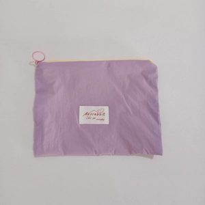 Detail of lavender nylon pouch featuring Mayrabbit woven label and pink circular zipper pull
