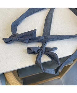 Detail of dark blue denim tote bag straps tied in elegant decorative bows