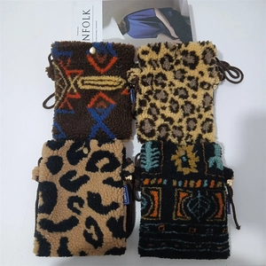 Detail shot of four plush mini crossbody bags with diverse geometric and leopard patterns