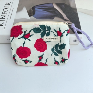 Close-up of floral cotton pouch with red rose patterns and zipper cord detail
