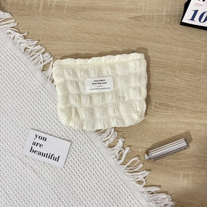 Macro detail of beige bubble cloud pouch with waffle texture and zip closure