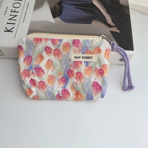 Close-up of floral canvas pouch with tulip pattern, metal zipper and purple woven strap