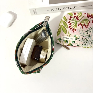 Detailed interior view of floral jacquard makeup bag holding cosmetics and lipstick