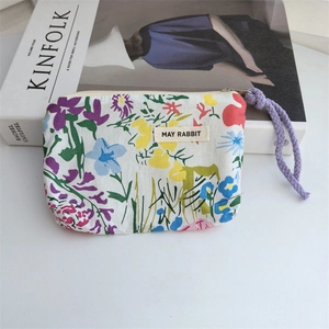 Macro detail of cotton floral pouch showing fabric texture and purple woven zipper strap