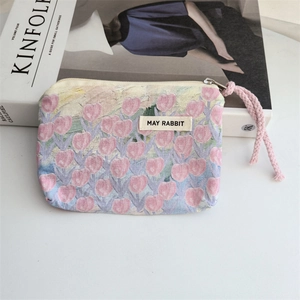 Detail of floral canvas makeup pouch with tulip print and pink drawstring zipper pull