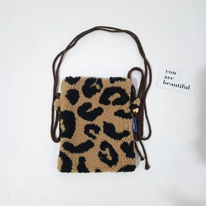 Detail of leopard print plush mini crossbody bag with brown woven rope strap and buckle