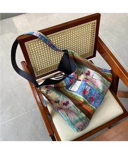 Detail of artistic floral pattern patchwork and SEEYOU label on large hobo shoulder bag