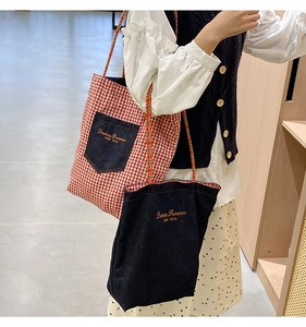 Dettaglio borse tote in vichy rosso e denim con ricamo e manici intrecciati colorati