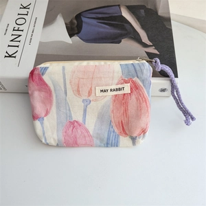 Detail of tulip floral cotton coin purse with purple woven zipper pull and woven label