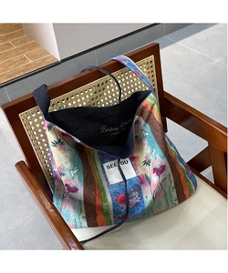 Close-up of ethnic tote bag with floral bird print, striped pattern and interior lining
