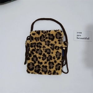 Detail view of leopard print plush mini crossbody bag with dark brown woven strap