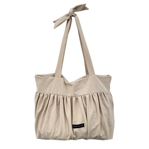 Minimalist beige cotton linen tote bag with pleated design and decorative bow strap