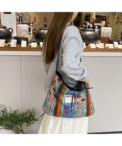 Detailed macro view of bohemian patchwork denim tote with colorful ethnic floral patterns