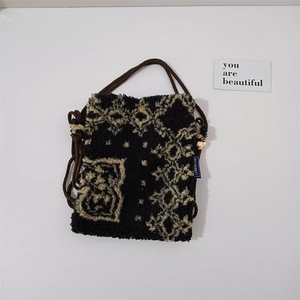 Detail of plush mini crossbody bag with ethnic patterns and soft texture