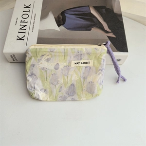 Detail of floral canvas coin purse with May Rabbit label and lavender zipper pull strap