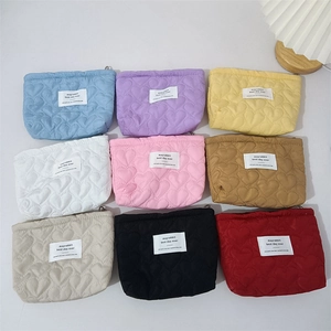 Quilted heart pattern makeup pouches in nine vibrant colors with woven brand labels