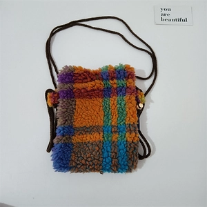 Close-up of colorful checkered plush mini crossbody bag with a brown woven rope strap