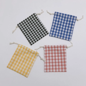 Detailed close-up of four plaid drawstring storage bags in cotton and linen material