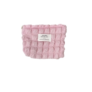 Pink bubble textured canvas cosmetic bag with zipper and logo label on white background