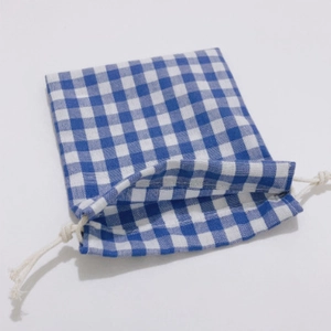Detail of blue and white plaid drawstring storage bag with cotton rope closure