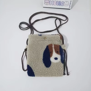 Detail of beige fleece mini phone bag featuring a cute cartoon dog patch and rope strap