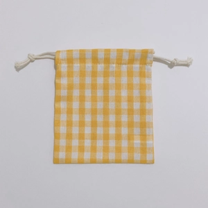 Top-down view of yellow plaid drawstring storage bag with premium cotton linen texture