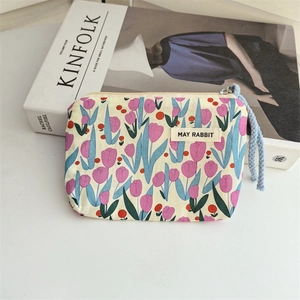 Detailed shot of floral cotton cosmetic bag with tulip pattern and woven zipper pull