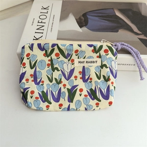 Detailed close-up of floral cotton pouch with zipper and May Rabbit woven label