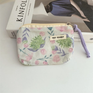 Detailed macro view of mint floral fabric coin purse with May Rabbit woven label